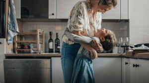 Grandmother and child hugging in kitchen
